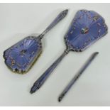 A white metal and enamel part dressing table set.