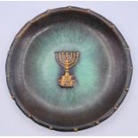 A metal wall plate with a Menorah.