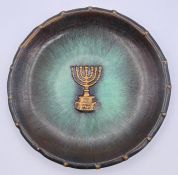 A metal wall plate with a Menorah.