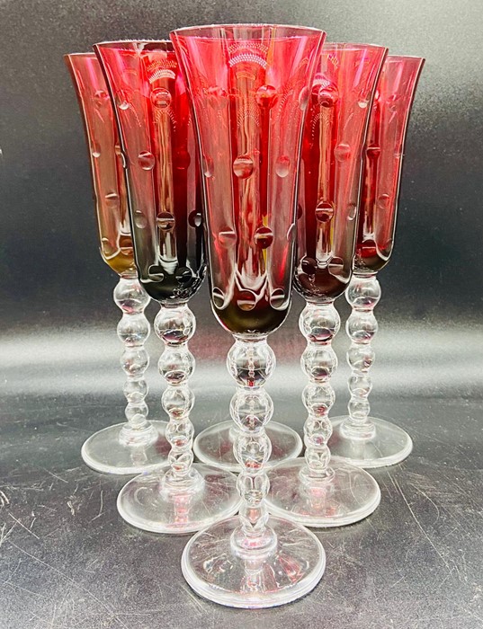 A set of six cranberry champagne flutes with bubble stems