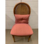 A cane back hall chair with pink upholstery seat and cushion