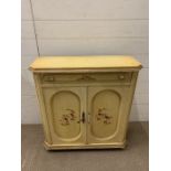 A painted side cabinet with floral details to doors (H76cm W70cm D26cm)