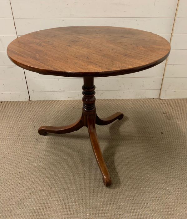 An oak center table on turned column, terminating on scroll feet, tilt top ( Diameter 84cm x 72cm