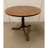 An oak center table on turned column, terminating on scroll feet, tilt top ( Diameter 84cm x 72cm