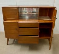 A Beautility teak side board consisting of four cupboards, three drawers and a sliding glass