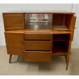 A Beautility teak side board consisting of four cupboards, three drawers and a sliding glass