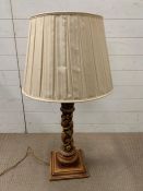 A Column lamp with grape vine theme and tiered base along with a raw silk shade