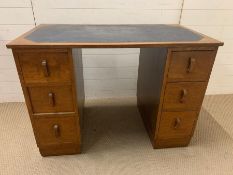 An Arts and Craft desk with blue leather top flanked with drawers (H78cm W108cm D62cm)