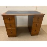 An Arts and Craft desk with blue leather top flanked with drawers (H78cm W108cm D62cm)