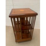 A Mahogany revolving bookcase with inlay flower crest to top 46 cm sq x 86 cm h