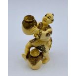 A signed ivory Netsuke of man and child with barrels.