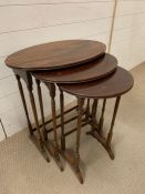 A set of three nesting tables on thin turned supports (H67cm W60cm D38cm)