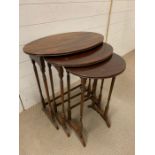 A set of three nesting tables on thin turned supports (H67cm W60cm D38cm)