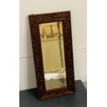 A carved oak framed hall mirror (56cm x26cm)