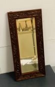 A carved oak framed hall mirror (56cm x26cm)