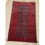 A red grounds rug or wall hanging with centre panel of geometric design (190cm x 115cm)