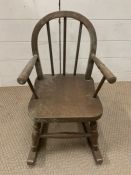 A children's stick back rocking chair