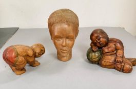 Three carved wooden figures, one bust of a women, one sleeping baby and one of a figure praying