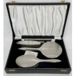 A silver backed Art Deco vanity set comprising two brushes, a comb and a mirror. By B & Co