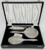 A silver backed Art Deco vanity set comprising two brushes, a comb and a mirror. By B & Co