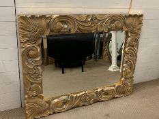 A large carved wall mirror with chunky scroll details (107cm x 139cm)