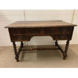 A carved Victorian oak desk carved in 17th century style with masks and scrolls, with 5 frieze
