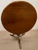 A circular mahogany tilt top table on a turned column and three splayed legs (H 68 cm x Diameter