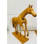 An artist model of a wooden horse on stand