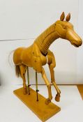 An artist model of a wooden horse on stand