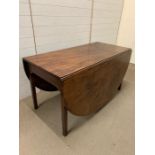 A mahogany drop leaf table, the oval top with square legs and gate action (H72cm W137)