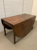 A mahogany drop leaf table, the oval top with square legs and gate action (H72cm W137)