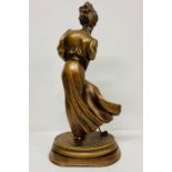 A gilt figure of a lady playing golf