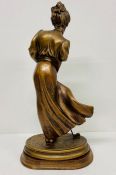 A gilt figure of a lady playing golf