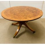 A Walnut center table, with burr walnut string inlay on sabre legs.