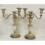 A pair of substantial three light silver on copper candlesticks