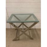 A glass and chrome X frame table (H60cm W59cm D44cm)