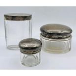 Three hallmarked silver topped glass jars.