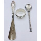 A silver spoon, napkin ring and a silver handled shoe horn.