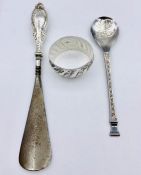 A silver spoon, napkin ring and a silver handled shoe horn.