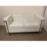 A two seater white faux leather sofa with chrome frame (marks to leather) (H68cm W130cm D70cm)