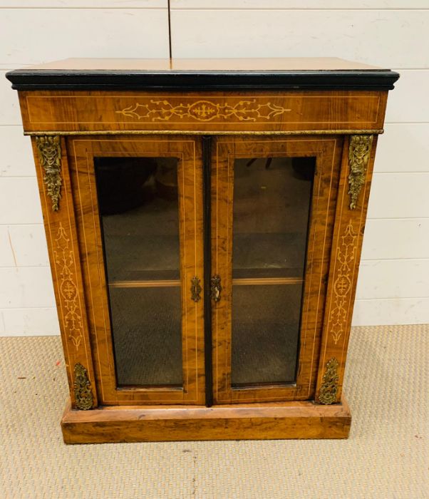 A Mahogany side cabinet with glazed doors to a single shelf, with string inlay and gilt. (60cm x