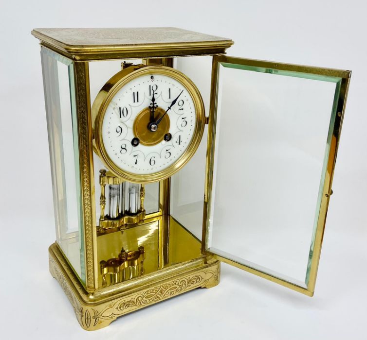 An eight day enamel faced eight day clock in a decorative engraved brass case. - Image 5 of 8