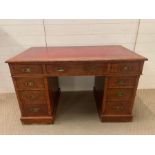 An oak three drawer pedestal desk with red leather top. (H72cm W122cm D65cm)