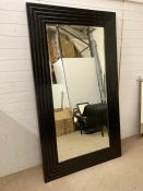 A Large black framed bevel edged mirror (210 cm x 121 cm)