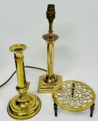 A collection of brass items, including a candlestick, a table lamp and a pot stand