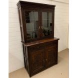 An oak carved dresser with glazed doors to top (H197cm W114cm D52cm)