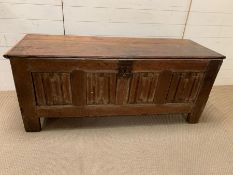 A four panel oak coffer possibly 16th Century with linen fold front (H62cm W149cm D53cm)