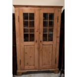 An Georgian pine cupboard with five shelves and part glazed doors