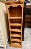 A narrow pine shelving unit