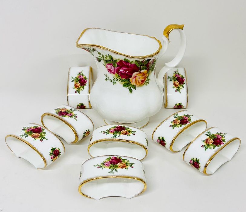 A Royal Albert Country Roses pattern milk jug and eight napkin rings